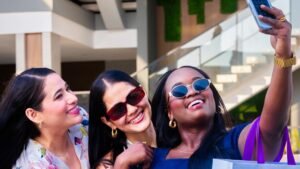 Tres amigas tomándose una selfie con bolsas de compras en Plaza Premier La Ceiba.
