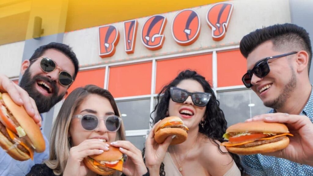 Grupo de amigos sonriendo y comiendo hamburguesas de Bigos en Catacamas.