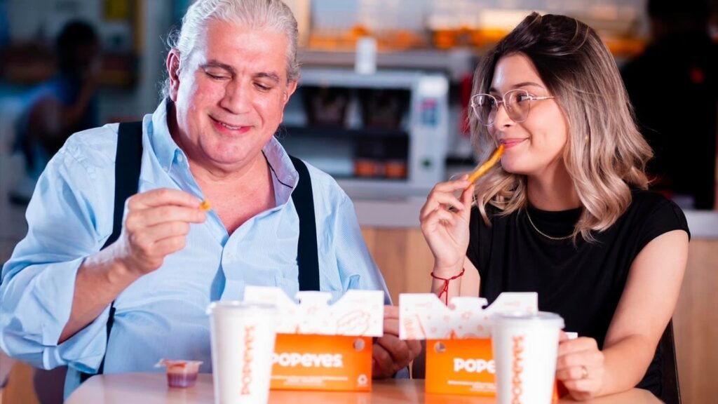 Padre e hija comiendo un combo de pollo de Popeyes en Mall Premier Catacamas.