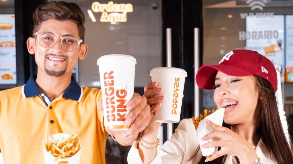 Pareja joven disfrutando de comida de Burger King y Popeyes en el tour foodie de Mall Premier Catacamas.