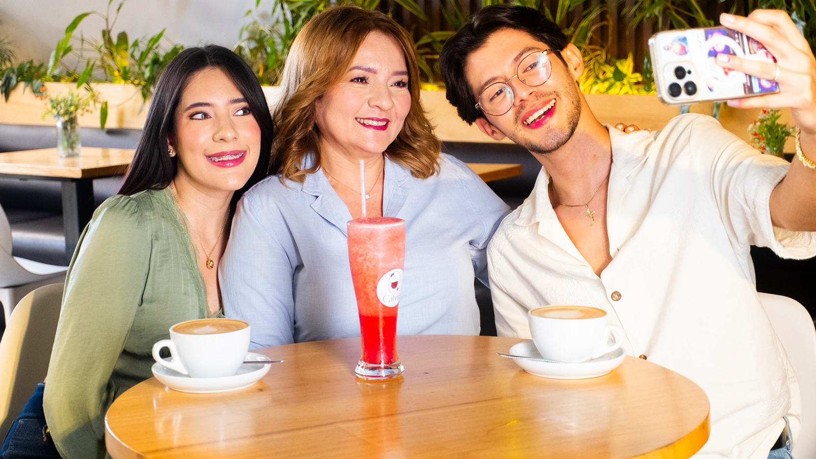 Familia tomándose una selfie mientras disfruta de cafés y bebidas frías en una cafetería de Mall Premier Tegucigalpa.