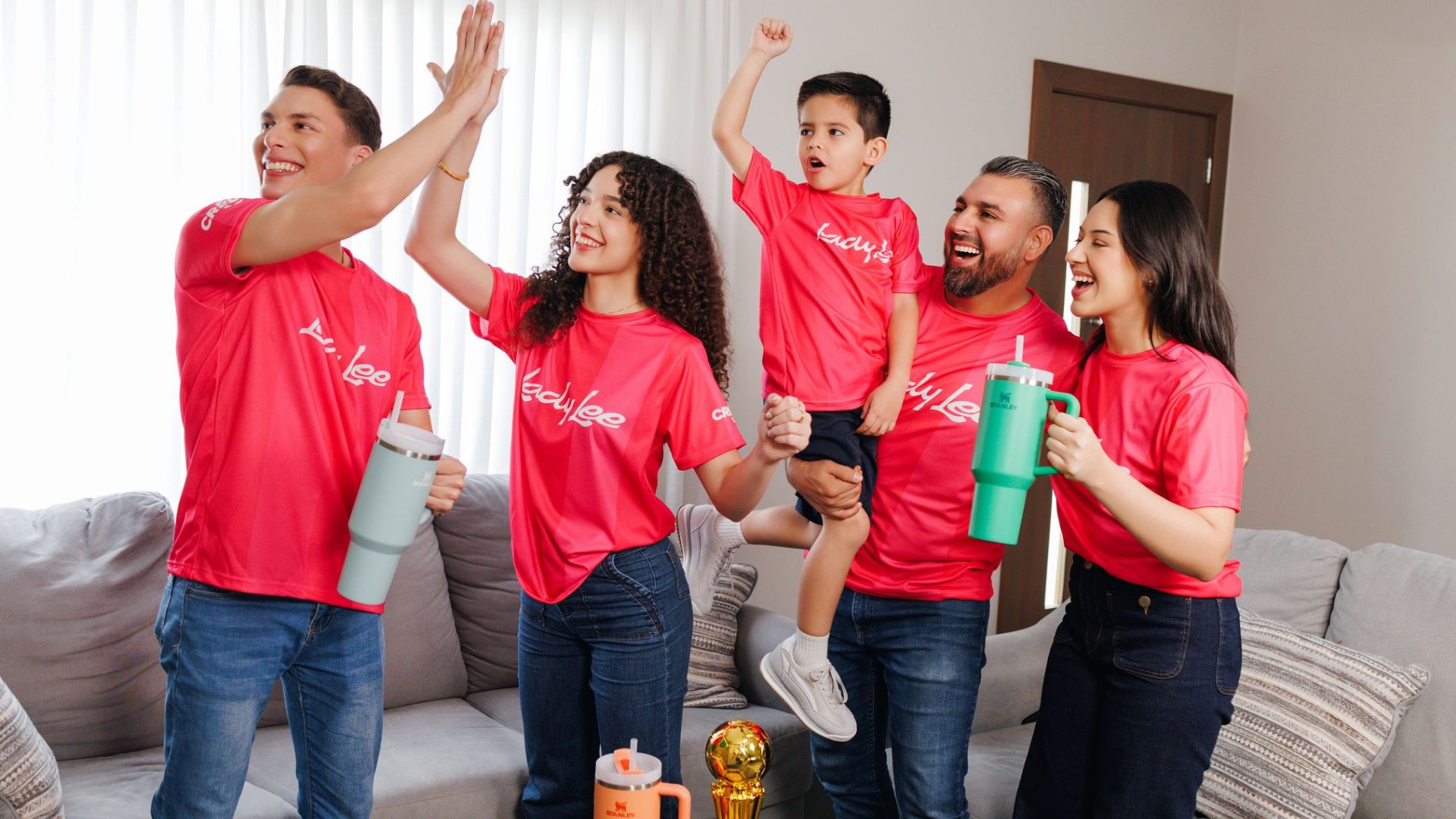 Grupo familiar celebrando un gol en un cómodo juego de sala equipado con productos para el hogar de la tienda Lady Lee en Mall Premier.